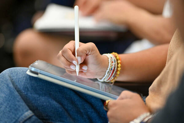 Student taking notes on a tablet computer