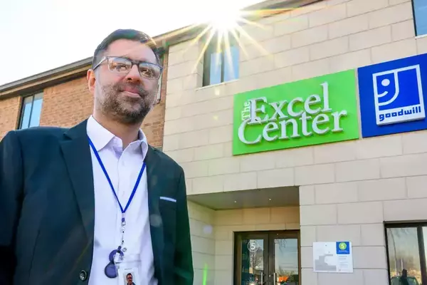 Rizan Hajji Mohamed stands in front of The Excel Center building in Indianapolis